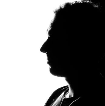 Black and white silhouette of a man's profile, captured in high contrast lighting.