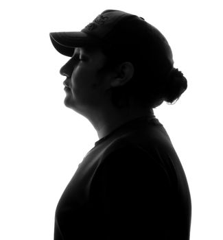 Dramatic black and white silhouette of a person in profile wearing a cap.